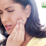 Woman touching her jaw in discomfort, showing signs of TMJ pain.